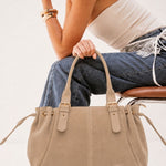 Sac cabas Garance beige tenu à la main, femme assise