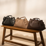 Sac à main Jane chocolat trois coloris posés sur un banc