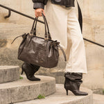 Sac à main Alba chocolat porté à la main sur des marches