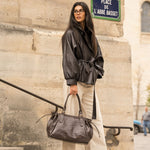 Sac à main Alba chocolat porté à la main, femme debout