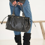 Sac à main Alba noir tenu à deux mains devant soi