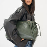 Sac à main Alba vert porté le long du corps