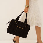 Sac à main Alva noir porté à la main, vue de profil