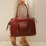 Sac à main Ariana bordeaux porté à la main, vue de face