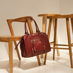 Sac à main Ariana bordeaux posé sur une chaise