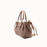 Sac à main Arles taupe porté à la main, vue de trois-quarts