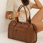 Sac à main Eléa camel tenu par l'anse, femme assise