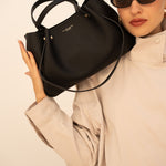 Sac à main Jane noir tenu à la main, vue de face