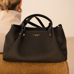 Sac à main Jane noir posé sur un siège, vue de face
