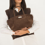 Sac à main Milae chocolat porté à la main devant soi