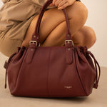 Sac cabas Elios bordeaux posé au sol, femme accroupie
