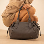 Sac cabas Elios chocolat tenu par l'anse, femme accroupie