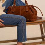 Garance camel tote bag on a bench, legs crossed