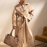 Sac cabas Garance taupe porté à la main avec un trench beige