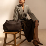Sac cabas Mary chocolat posé sur un banc, femme assise