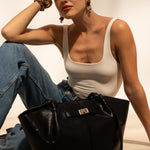 Sac cabas Solène noir posé au sol, femme assise
