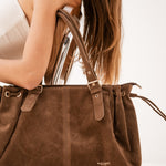 Sac cabas Garance chocolat tenu à la main, détail du logo et des boucles