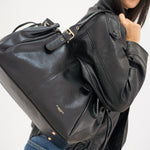 Sac à main Iria noir porté à l'épaule, vue de trois-quarts dos
