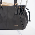 Sac à main Iria noir posé sur une chaise, vue de face